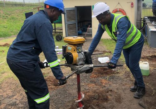 Workers using a ground drill.